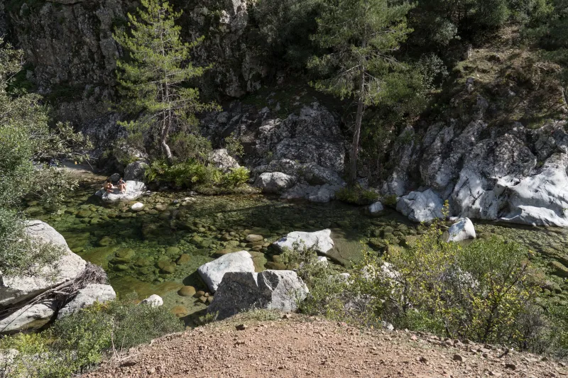 La rivière du Tavignano au milieu des roches et de la végétation.